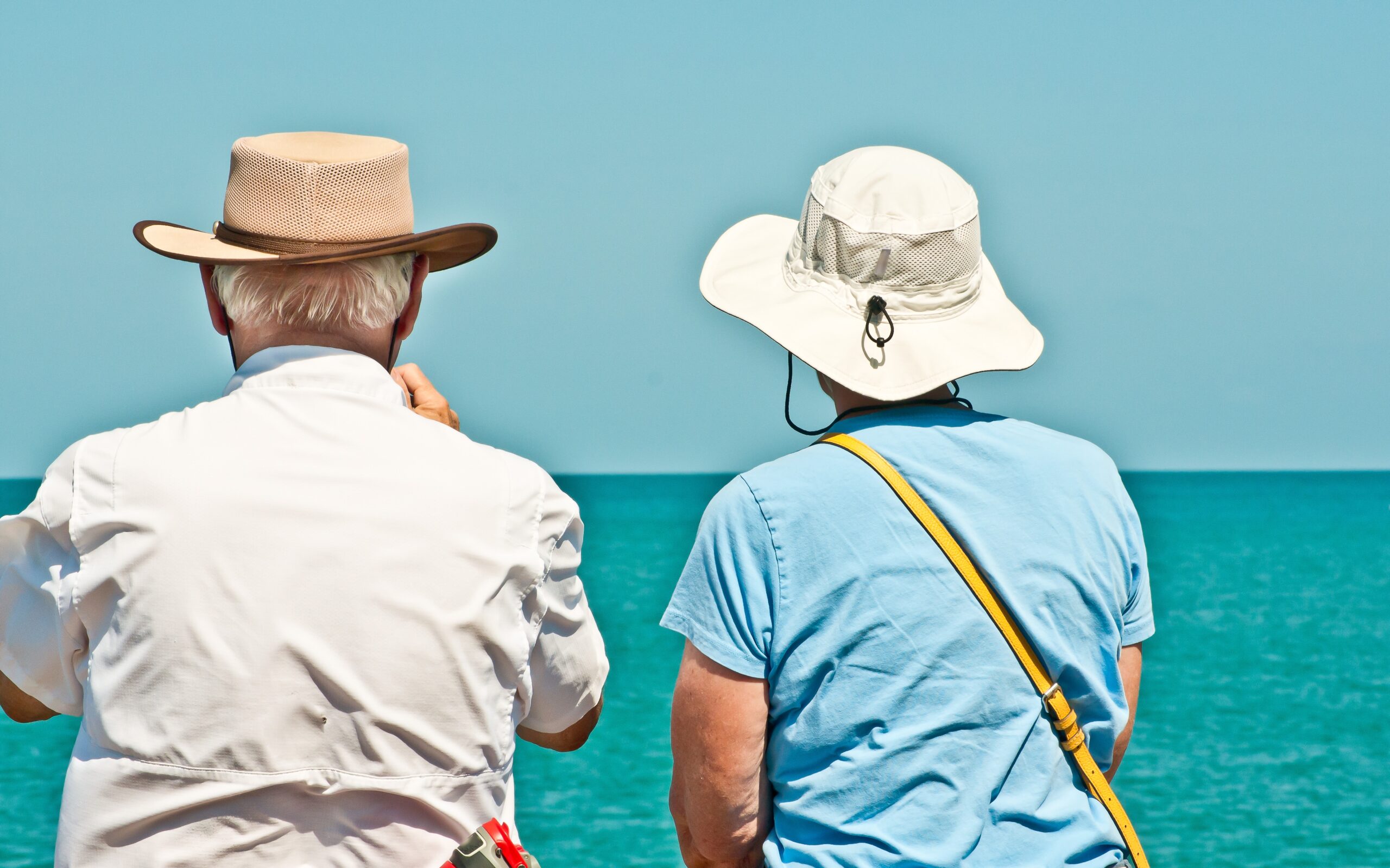 Two Seniors wearing hats by the beach