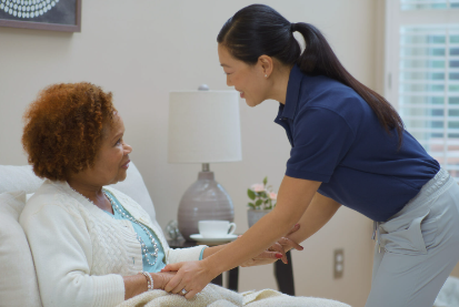 Caregiver assisting an elderly woman.