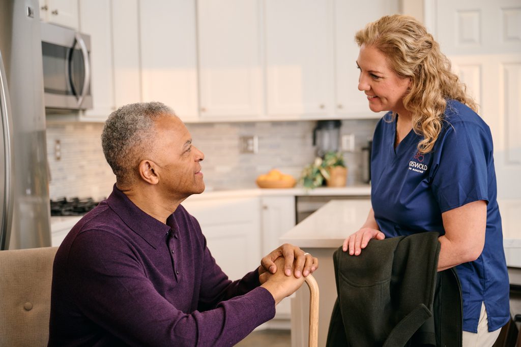 Caregiver helping Client with daily routine during post-surgery recovery care support.