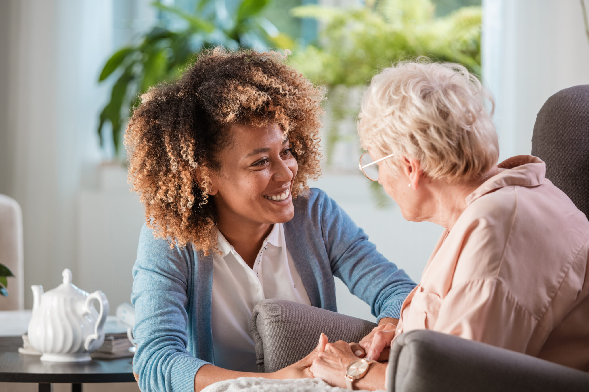 A Caregiver smiling at a client who is facing away from the camera.